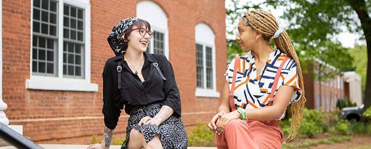 two students smiling at each other in profile