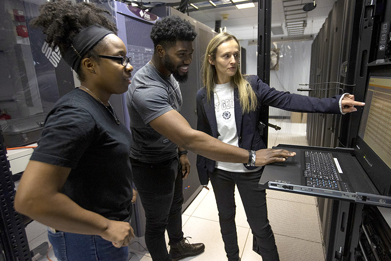 students in control room with faculty member