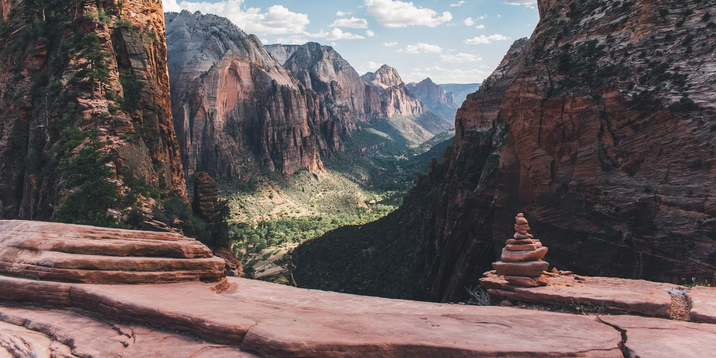 Scenic picture looking into a deep canyon, featuring cliffs with rocky formations.