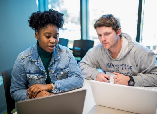 two students behind laptops