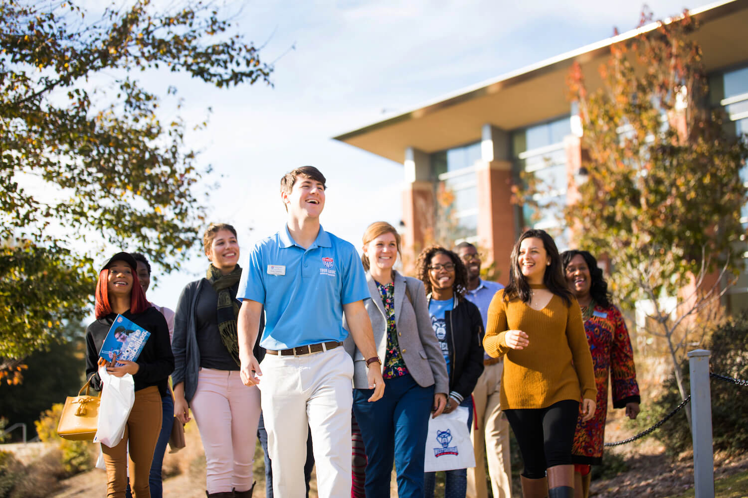 Campus tour guide leading a tour across campus and pointing out unique points of interest.