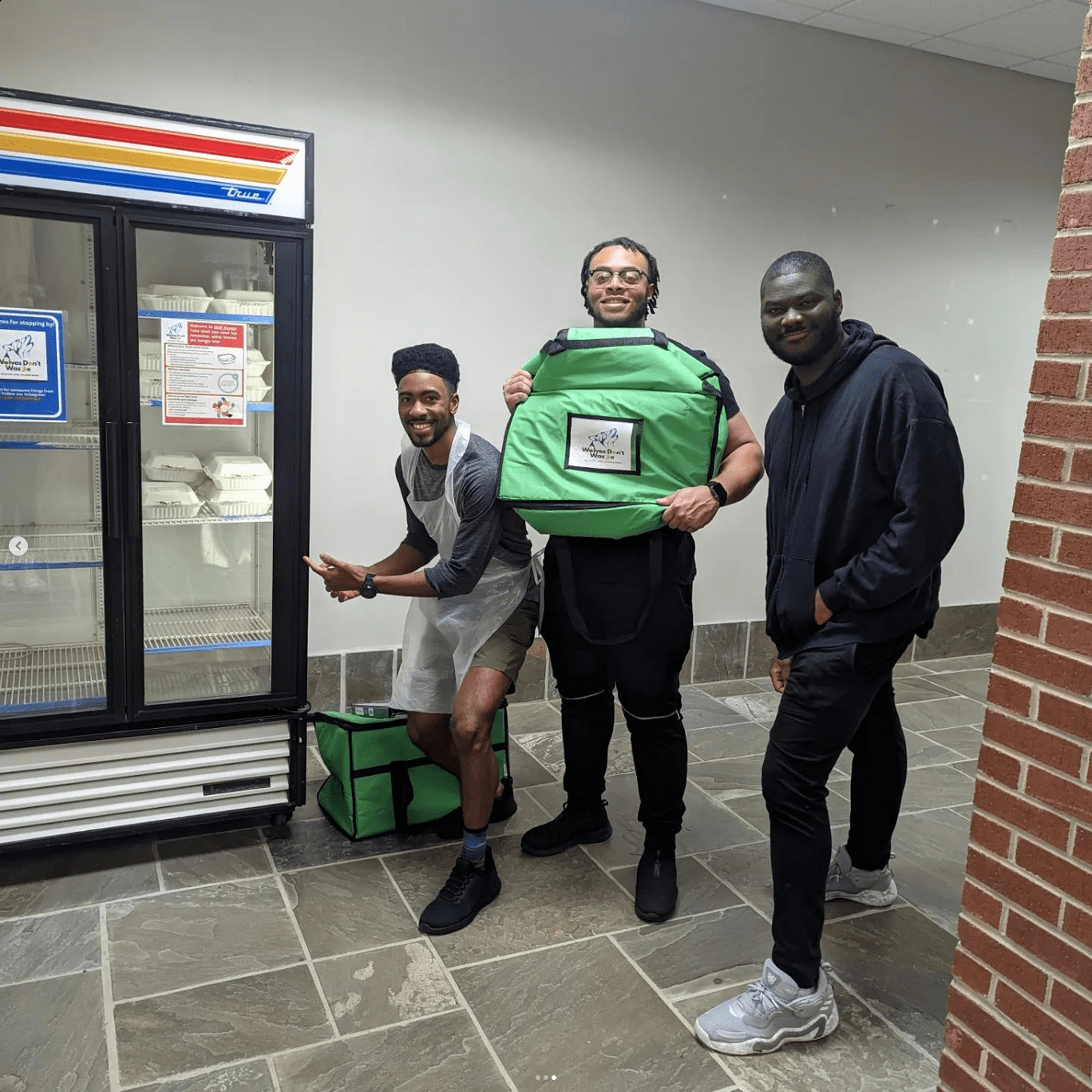 Students with insulated travel containers supply food to the Wolf Haven Fridges.